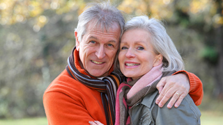 Pareja de mayores sonriendo abrazados 