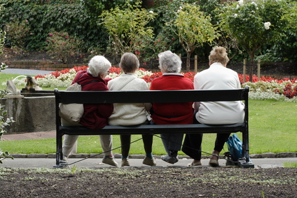 4 mujeres mayores sentadas en un banco 