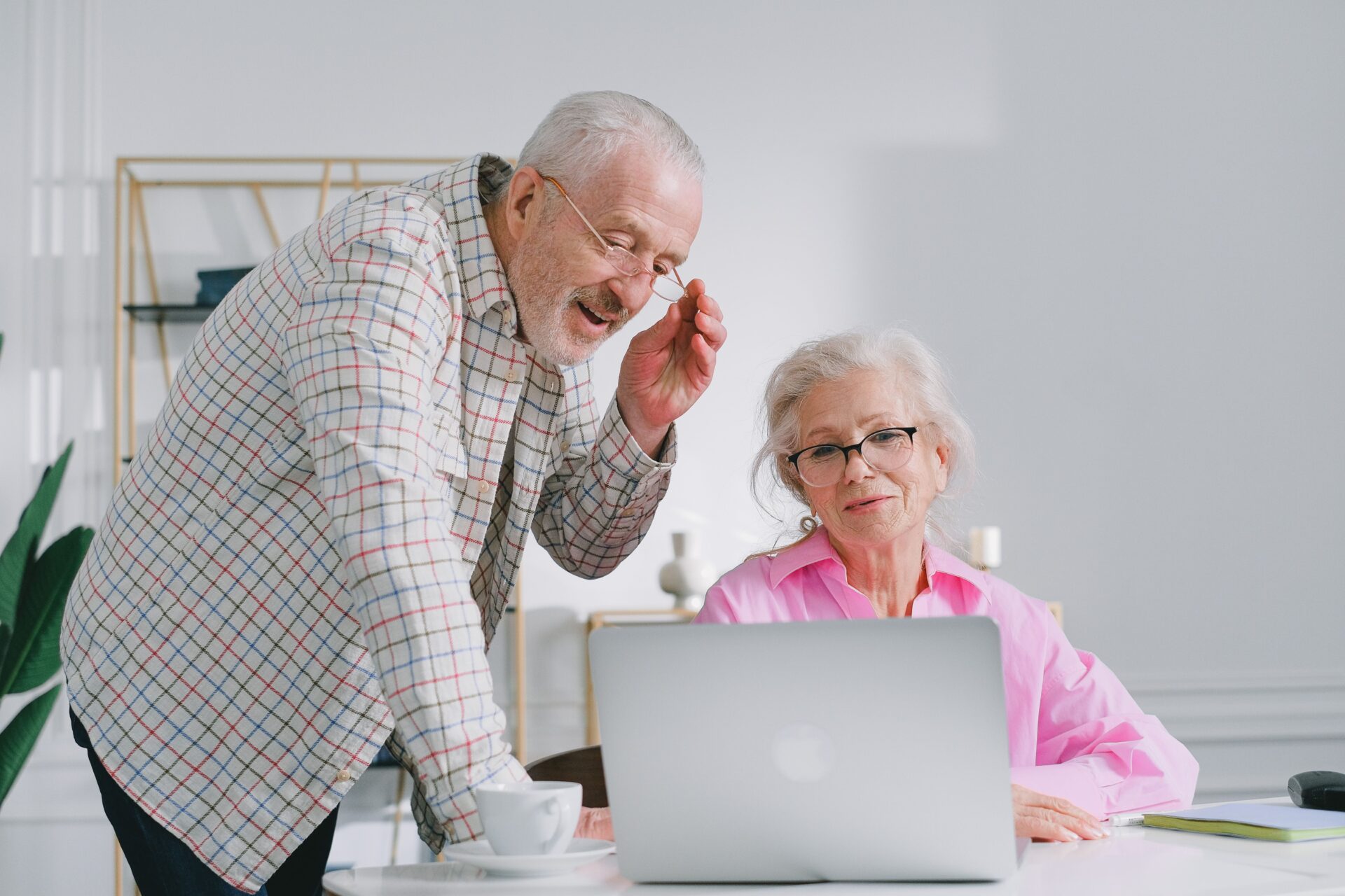 Pareja de personas mayores consultando un ordenador, una actividad relacionada con la planificación patrimonial para la jubilación.